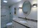 Modern bathroom featuring tiled shower, granite vanity top, silver mirror, and sconce lighting at 6060 Shore S Blvd # 903, Gulfport, FL 33707