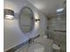 Bright bathroom with granite countertop, tiled shower, silver mirror, and modern sconce lighting at 6060 Shore S Blvd # 903, Gulfport, FL 33707