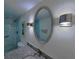 Well-lit bathroom featuring granite vanity top, oval mirror, modern vanity lights and a tiled shower at 6060 Shore S Blvd # 903, Gulfport, FL 33707