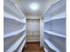 Walk-in closet featuring white shelving, wood floor, and hanging rods at 6060 Shore S Blvd # 903, Gulfport, FL 33707