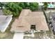 Aerial view of single-story home showcasing the roof, landscaping, driveway, and proximity to neighboring houses at 613 Sandy Hollow Rd, Tarpon Springs, FL 34689