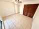 Bedroom with tile flooring, ceiling fan, and a closet with folding doors at 613 Sandy Hollow Rd, Tarpon Springs, FL 34689