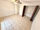 Neutral bedroom with tiled floor, ceiling fan, open closet and adjacent doorway at 613 Sandy Hollow Rd, Tarpon Springs, FL 34689