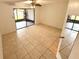 Neutral tiled bedroom with ceiling fan and sliding glass doors to outdoor space at 613 Sandy Hollow Rd, Tarpon Springs, FL 34689