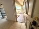 View from the tiled entryway looking through the open front door to the landscaped front yard at 613 Sandy Hollow Rd, Tarpon Springs, FL 34689