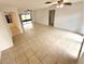 Spacious open-concept living room featuring neutral tile floors, ceiling fans, and access to outdoor spaces at 613 Sandy Hollow Rd, Tarpon Springs, FL 34689