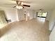 Inviting living room features tile flooring, ceiling fans, and seamless access to the screened lanai at 613 Sandy Hollow Rd, Tarpon Springs, FL 34689