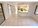 Open-concept living room and kitchen with tile flooring, stainless steel appliances, and natural light at 613 Sandy Hollow Rd, Tarpon Springs, FL 34689