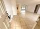 Bright living room boasts neutral tile flooring, ceiling fan, and sliding glass doors to the lanai at 613 Sandy Hollow Rd, Tarpon Springs, FL 34689
