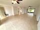 Open living space with tile flooring, ceiling fans, neutral walls, and access to outdoor lanai at 613 Sandy Hollow Rd, Tarpon Springs, FL 34689