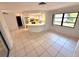 Open living room with tiled floors leading to a bright kitchen at 613 Sandy Hollow Rd, Tarpon Springs, FL 34689