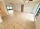 Bright and airy living room showcases tile flooring, a ceiling fan, and access to a screened lanai at 613 Sandy Hollow Rd, Tarpon Springs, FL 34689