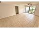 The living room offers neutral paint, tile floors, a ceiling fan, and a large window at 613 Sandy Hollow Rd, Tarpon Springs, FL 34689