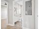 Hallway view leading to a stylish bathroom with unique floral tile and updated fixtures at 6433 Werner Ave, New Port Richey, FL 34652