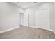 Bedroom with wood-look tile floors, bright walls, and a closet with louvered doors at 6433 Werner Ave, New Port Richey, FL 34652