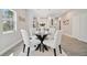 Dining area features a glass table with wood base and modern white chairs on a plush rug at 6433 Werner Ave, New Port Richey, FL 34652