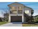 Inviting two-story home with a neutral color scheme, garage, and charming staircase leading to the main entrance at 6433 Werner Ave, New Port Richey, FL 34652