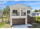 Charming two-story home features a brown garage door, exterior stairs, and a light exterior at 6433 Werner Ave, New Port Richey, FL 34652