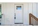 A well-lit front door framed by white trim and siding creates a clean, inviting entryway to the residence at 6433 Werner Ave, New Port Richey, FL 34652