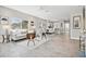 Bright open-concept living area with modern furniture, tile flooring, and seamless connection to the dining and kitchen at 6433 Werner Ave, New Port Richey, FL 34652