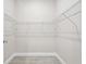 Walk-in closet featuring wire shelving, tile flooring, and ample storage space at 6433 Werner Ave, New Port Richey, FL 34652