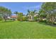 Lush green backyard with manicured lawn and mature trees at 6468 Rubia Cir, Apollo Beach, FL 33572
