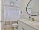 Cozy bathroom with a framed round mirror and shower with a curtain at 6468 Rubia Cir, Apollo Beach, FL 33572