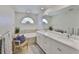 Bright bathroom with a double sink vanity, soaking tub, and neutral tile at 6468 Rubia Cir, Apollo Beach, FL 33572