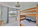 This bedroom features a wooden bunk bed, window with palm tree view, and ceiling fan at 6468 Rubia Cir, Apollo Beach, FL 33572