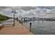 View of a marina with boats docked along a wooden pier under a cloudy sky at 6468 Rubia Cir, Apollo Beach, FL 33572