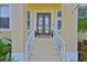 Front entrance of the home featuring double doors, sidelights, and a covered porch with columns at 6468 Rubia Cir, Apollo Beach, FL 33572