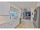 Bright kitchen with a large window, white cabinets, stainless steel appliances, and open sight lines at 6468 Rubia Cir, Apollo Beach, FL 33572