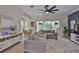 Open-concept living room with neutral decor, ceiling fan, and sliding glass doors leading to the outdoors at 6468 Rubia Cir, Apollo Beach, FL 33572