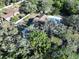 Aerial view of a home with a pool, mature trees, and beautiful surroundings at 6602 Winding Brook Dr, New Port Richey, FL 34655