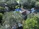 Aerial view showcasing a pool home surrounded by lush landscaping and mature trees at 6602 Winding Brook Dr, New Port Richey, FL 34655