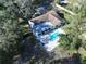 Aerial view of a single-Gathering home with a pool and covered patio amid lush, mature trees at 6602 Winding Brook Dr, New Port Richey, FL 34655