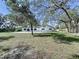 Large backyard with mature trees and an open grassy area at 6602 Winding Brook Dr, New Port Richey, FL 34655