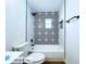 Modern bathroom with a decorative tiled accent wall above the bathtub at 6602 Winding Brook Dr, New Port Richey, FL 34655