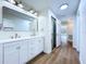 Bright bathroom with double vanity, modern fixtures, large mirror, and wood flooring at 6602 Winding Brook Dr, New Port Richey, FL 34655