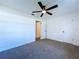 Clean bedroom with neutral carpet, ceiling fan, and white walls with an open doorway at 6602 Winding Brook Dr, New Port Richey, FL 34655