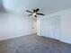 A bright bedroom with plush carpet, a ceiling fan and a closet with folding doors at 6602 Winding Brook Dr, New Port Richey, FL 34655