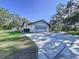 Home boasts a long driveway and attached garage, surrounded by mature trees, offering privacy at 6602 Winding Brook Dr, New Port Richey, FL 34655