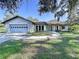 Charming single-story home with a stone facade, mature trees, and a well-maintained front lawn at 6602 Winding Brook Dr, New Port Richey, FL 34655