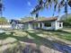 Charming one-story home featuring a stone facade, well-manicured lawn, and mature landscaping with mossy trees at 6602 Winding Brook Dr, New Port Richey, FL 34655