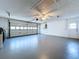 Interior view of an empty, painted garage with a ceiling fan, automatic garage door and utility door at 6602 Winding Brook Dr, New Port Richey, FL 34655