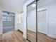 Hallway featuring hard wood floors with a bathroom and mirror closet in view at 6602 Winding Brook Dr, New Port Richey, FL 34655