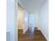 Bright hallway leads to various rooms, featuring modern wood-look flooring and clean white walls at 6602 Winding Brook Dr, New Port Richey, FL 34655