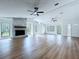 Bright living room with a stone fireplace, hardwood floors, and large windows at 6602 Winding Brook Dr, New Port Richey, FL 34655