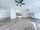 Expansive open-concept living area with hardwood floors, ceiling fans, and a view of the modern kitchen at 6602 Winding Brook Dr, New Port Richey, FL 34655
