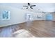 Spacious living room with hardwood floors, ceiling fans, and large windows for natural light at 6602 Winding Brook Dr, New Port Richey, FL 34655